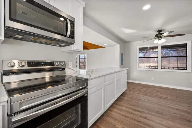a kitchen with stainless steel appliances granite countertop a stove and a microwave