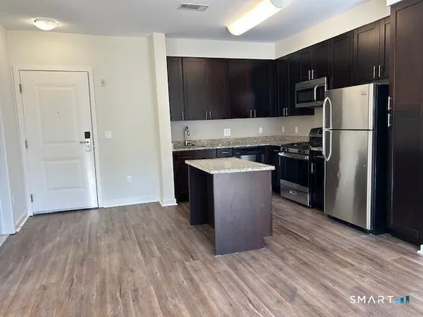a kitchen with a sink a refrigerator and cabinets