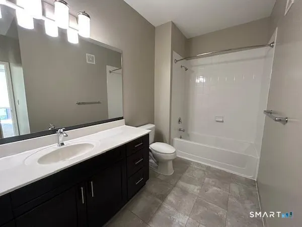 a bathroom with a double vanity sink toilet and shower