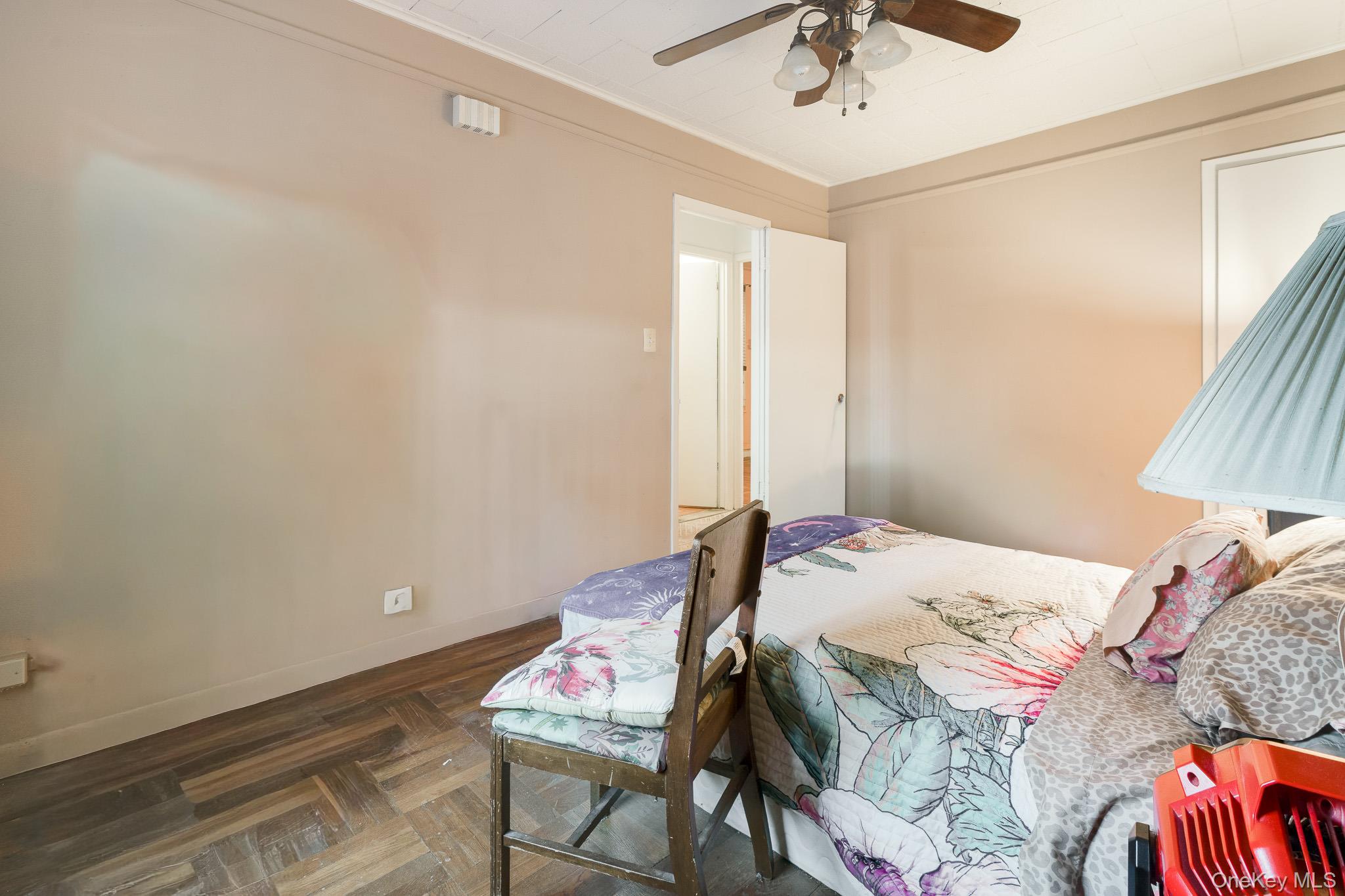 2437 Buck Street Bronx, NY 10461 - Photo 12 of 38 a bedroom with a bed and a chandelier