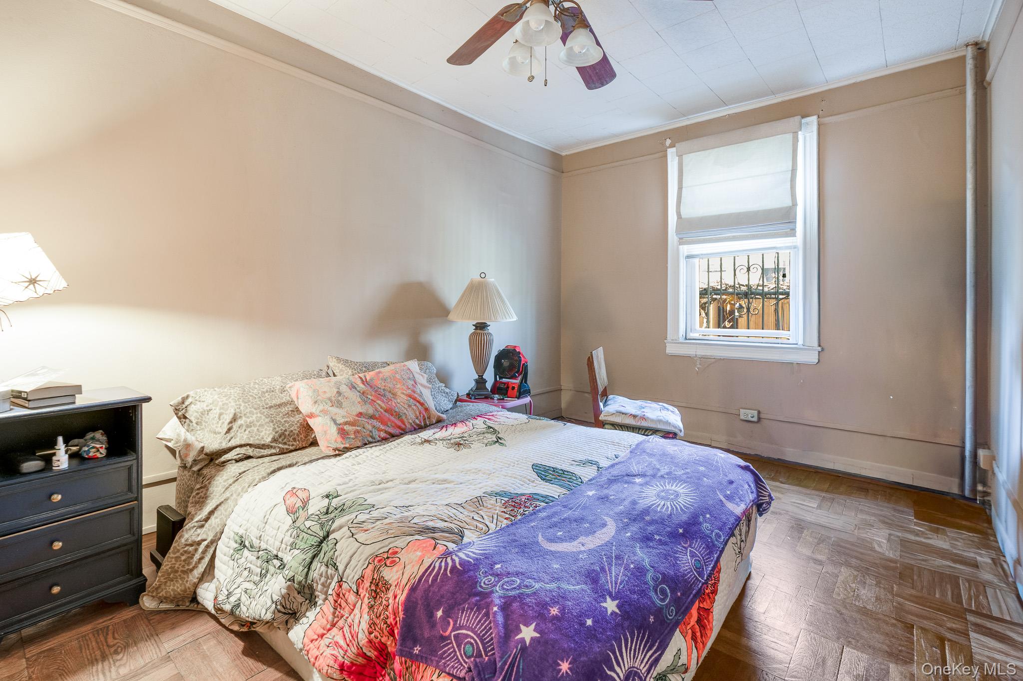 2437 Buck Street Bronx, NY 10461 - Photo 17 of 38 a bedroom with a bed and a chandelier