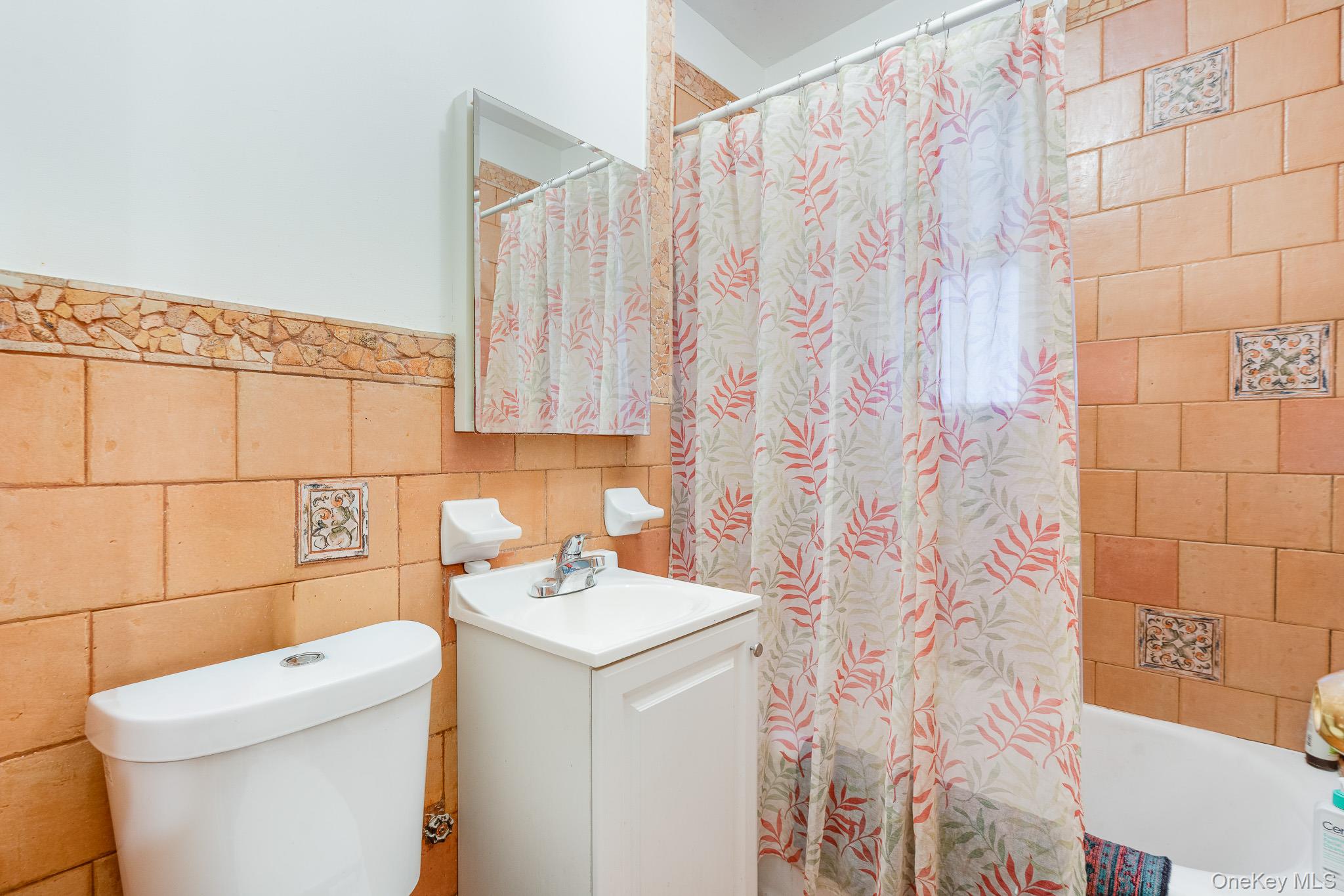 2437 Buck Street Bronx, NY 10461 - Photo 10 of 38 a bathroom with a sink a toilet and shower curtain