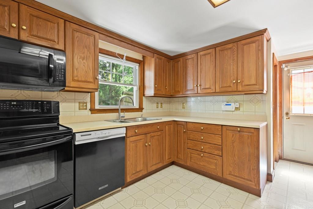19 Ronald Road Arlington, MA 02474 - Photo 11 of 28 a kitchen with stainless steel appliances granite countertop a stove a sink and a microwave