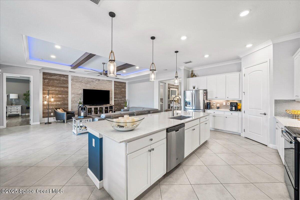 2190 Caravan Place Melbourne, FL 32940 - Photo 19 of 46 a large kitchen with stainless steel appliances kitchen island granite countertop a sink and cabinets