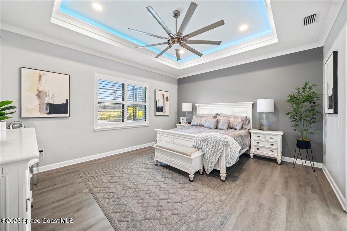 2190 Caravan Place Melbourne, FL 32940 - Photo 24 of 46 a bedroom with a large bed chandelier and a window