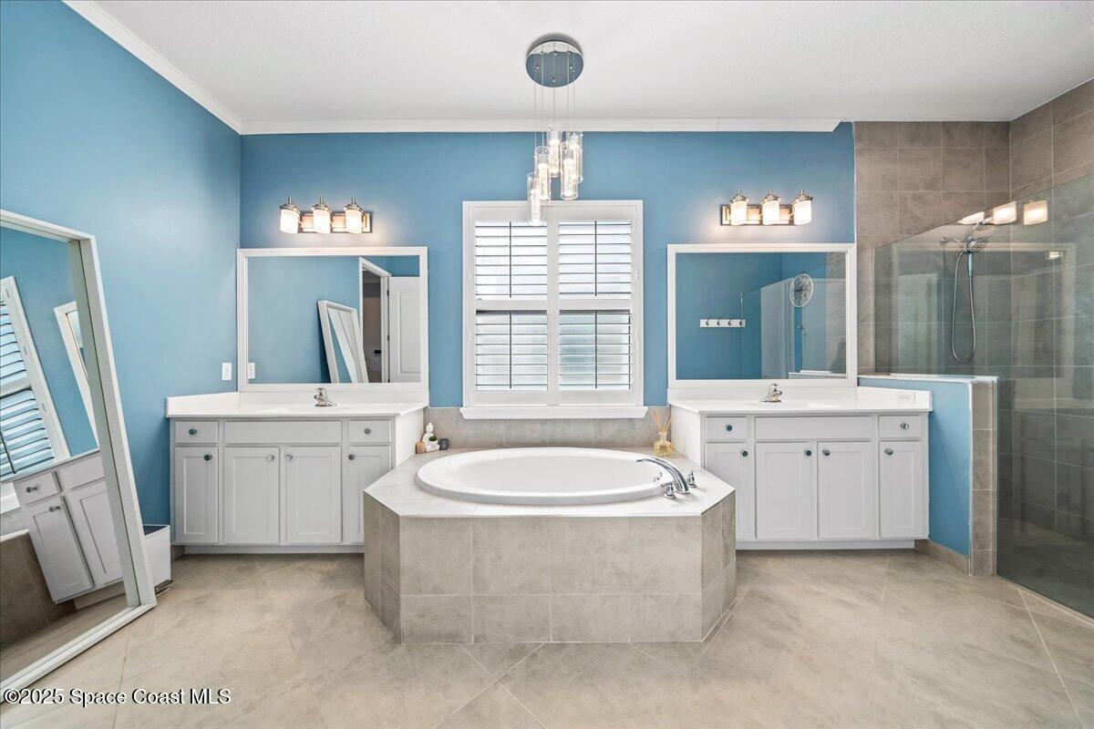 2190 Caravan Place Melbourne, FL 32940 - Photo 26 of 46 a spacious bathroom with a double vanity sink a mirror a bathtub and shower