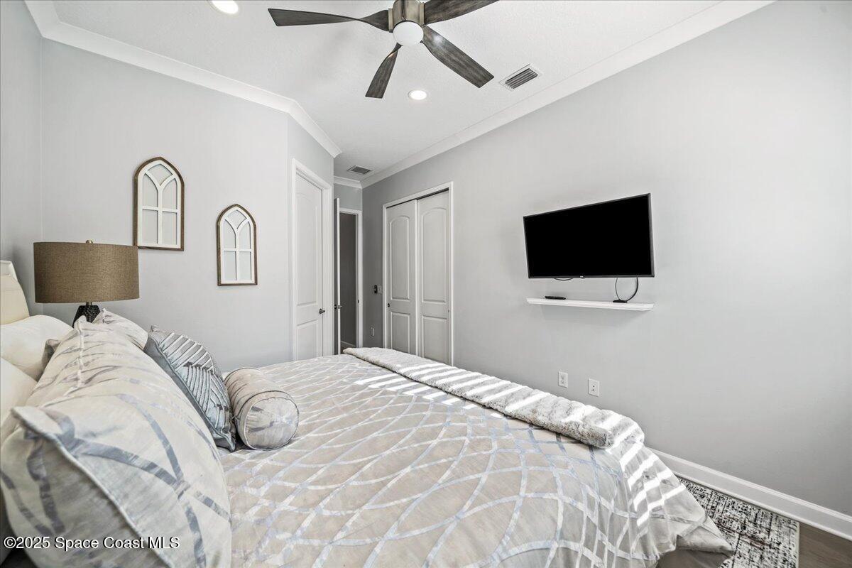 2190 Caravan Place Melbourne, FL 32940 - Photo 32 of 46 a bedroom with a bed and a flat screen tv