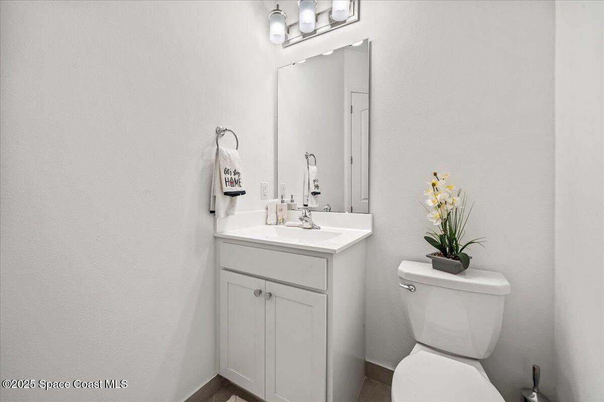 2190 Caravan Place Melbourne, FL 32940 - Photo 34 of 46 a bathroom with a toilet sink and mirror