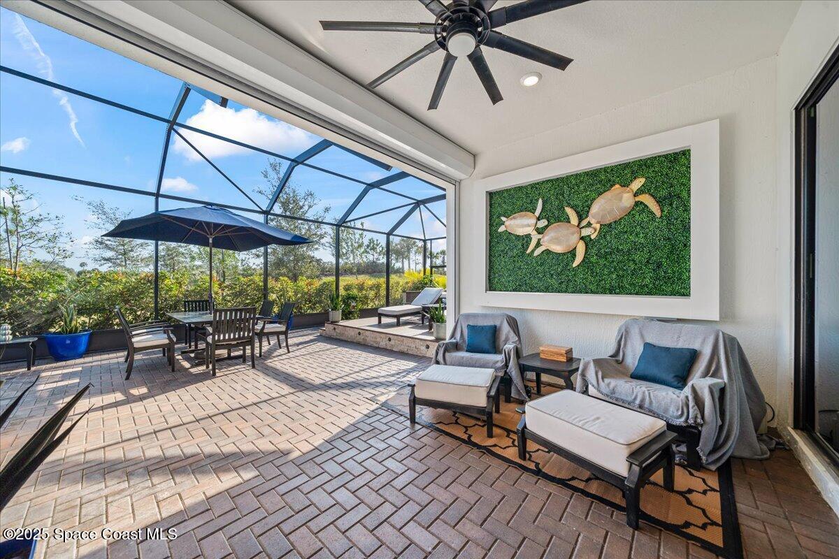 2190 Caravan Place Melbourne, FL 32940 - Photo 9 of 46 a view of a patio with a dining table and chairs under an umbrella