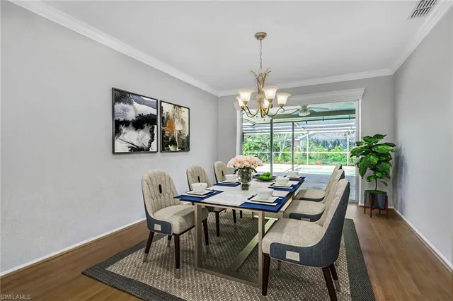 a dining room with furniture a chandelier and wooden floor