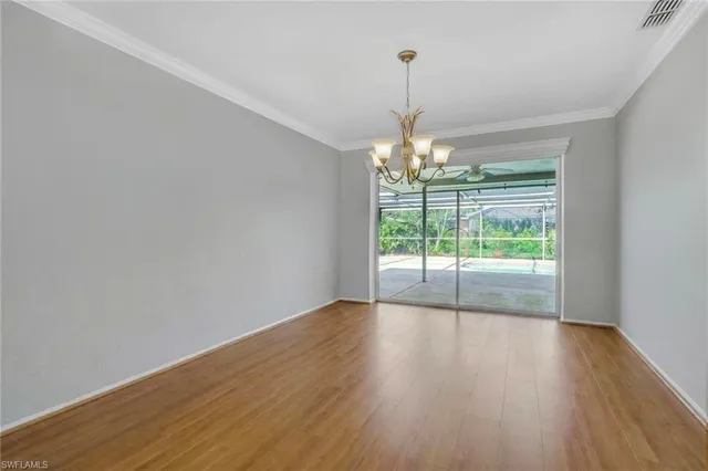 a view of empty room with wooden floor fan and window