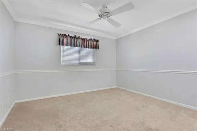 an empty room with windows and ceiling fan