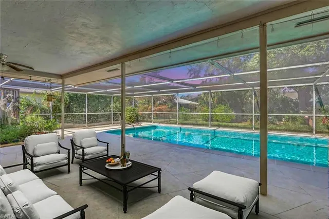 a living room with furniture and a floor to ceiling window