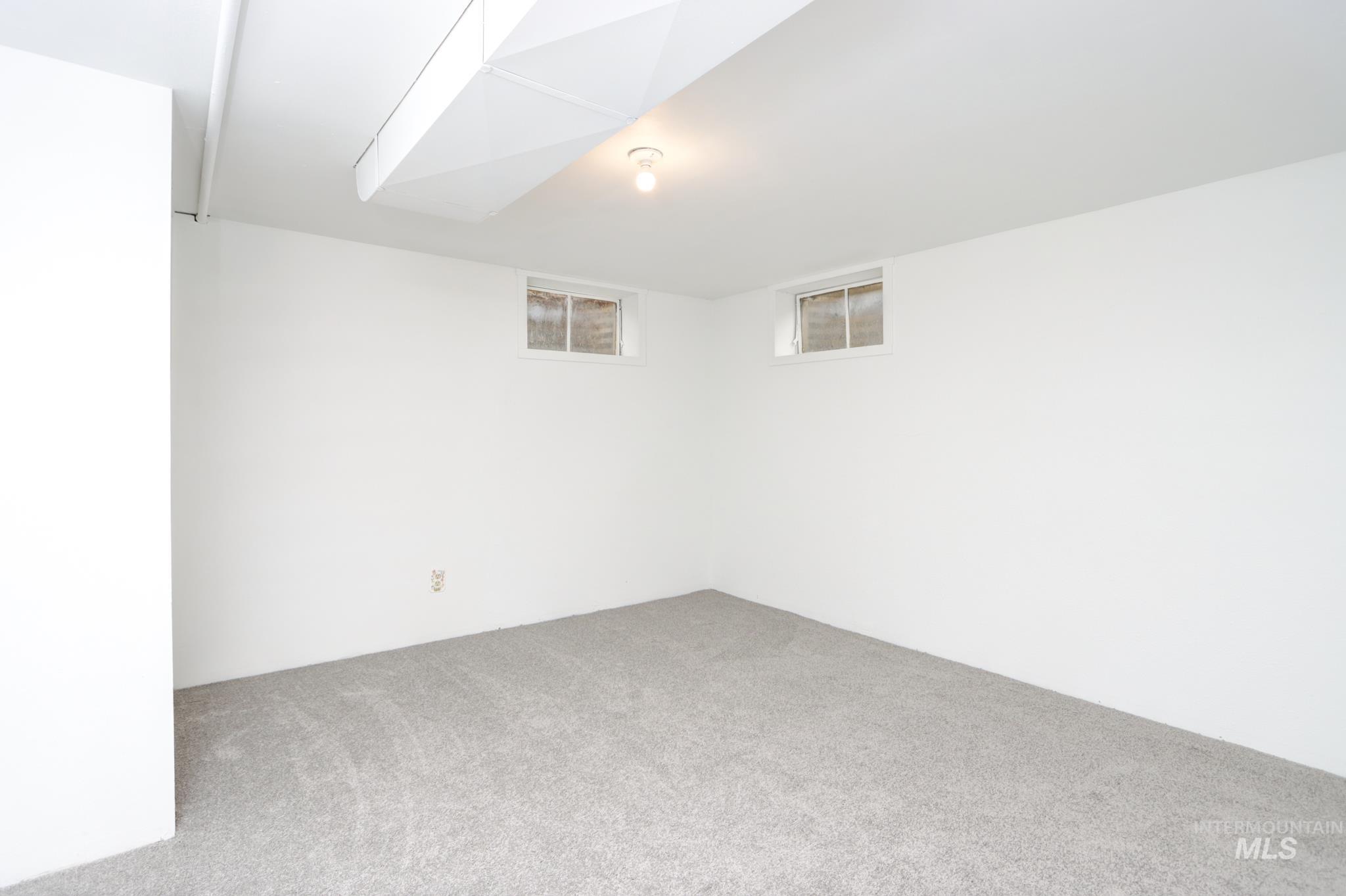801 Thompson Avenue Nyssa, OR 97913 - Photo 28 of 46 Finished lower level space featuring light gray carpeting, white painted walls, and two horizontal windows