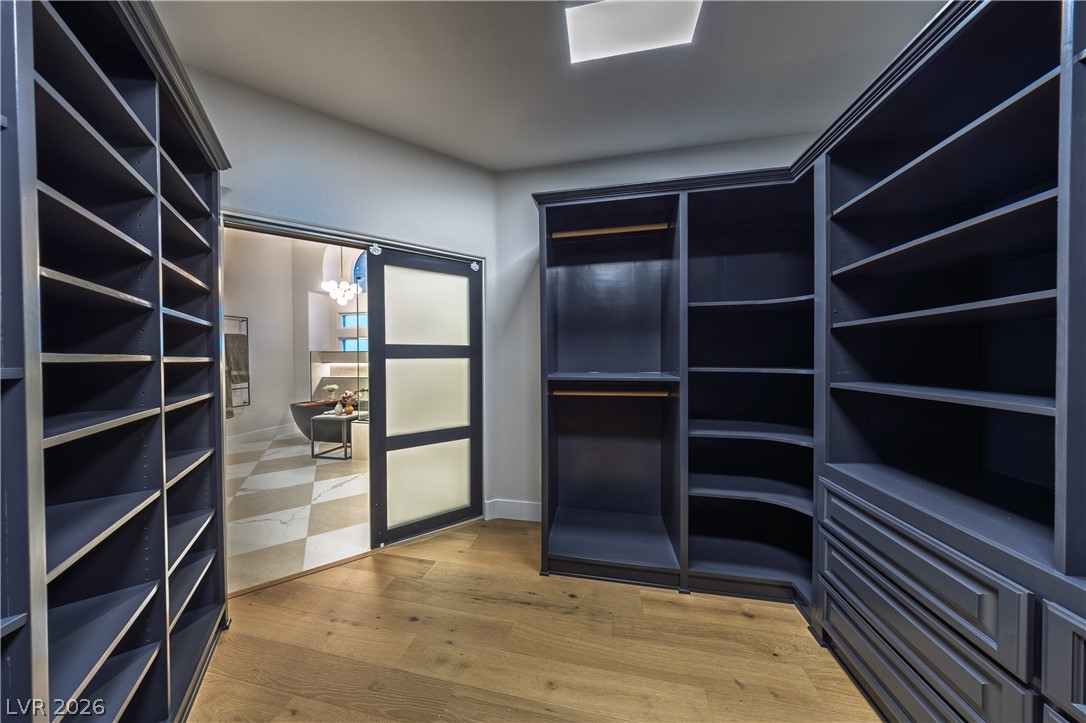 8800 Lusso Las Vegas, NV 89134 - Photo 53 of 85 Walk in closet with light wood-style flooring and a chandelier