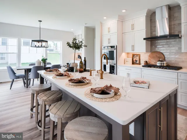 a kitchen with stainless steel appliances a sink dishwasher a refrigerator and a stove with wooden floor