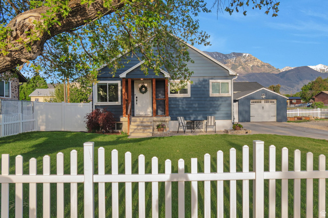 1024 200 East Orem, UT 84057 - Photo 1 of 1 View of front of home featuring a fenced front yard, a mountain view, a garage, and asphalt driveway