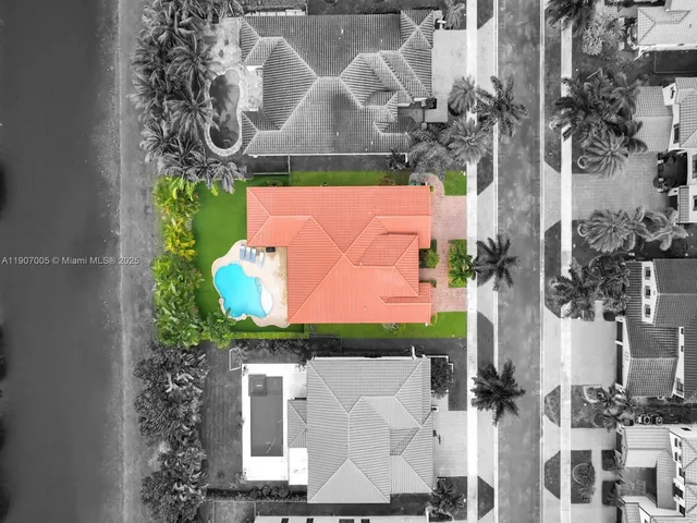an aerial view of a house with a yard and large trees