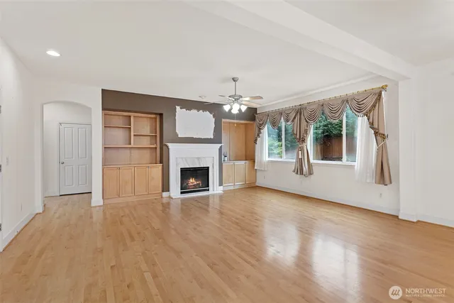 a view of a livingroom with wooden floor and a fireplace