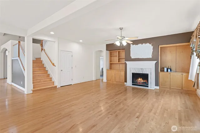 a view of a livingroom with wooden floor a fireplace and window