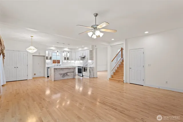 a view of a room with wooden floor and a ceiling fan