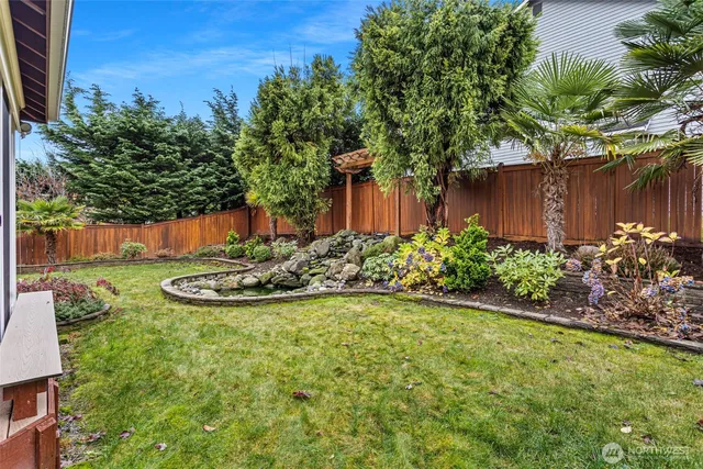 a view of a backyard with plants and a bench