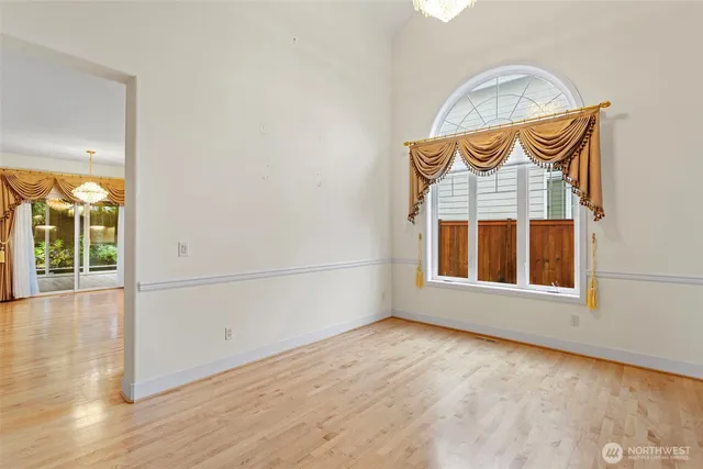 an empty room with wooden floor and fan