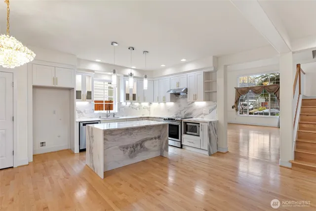 a kitchen with stainless steel appliances granite countertop a refrigerator and a stove top oven