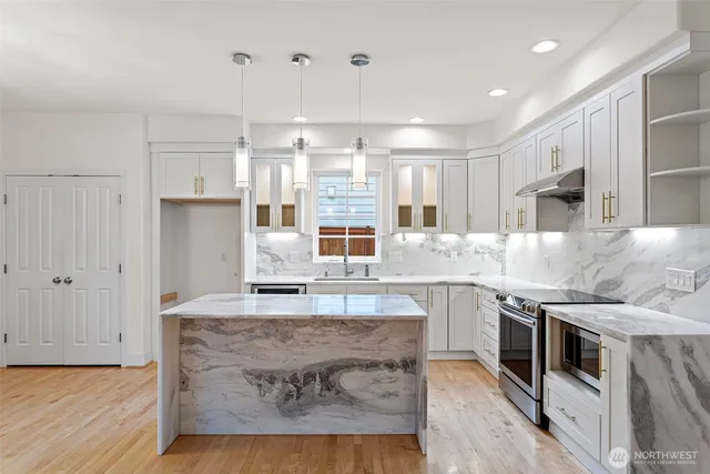 a kitchen with stainless steel appliances granite countertop a stove and a sink
