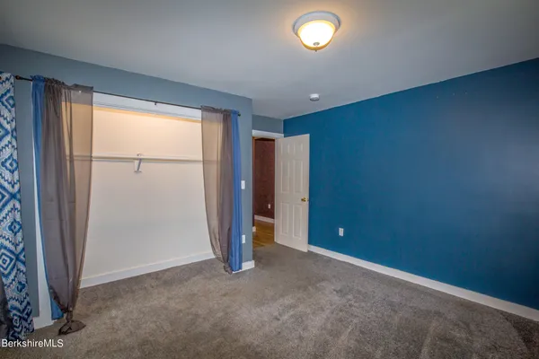 an empty room with closet and a window