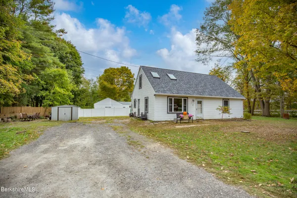 a view of a house with a big yard and large trees