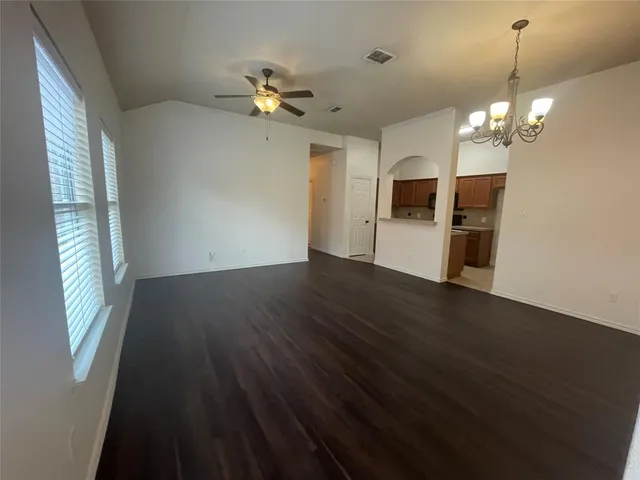 a view of a livingroom with wooden floor and a ceiling fan