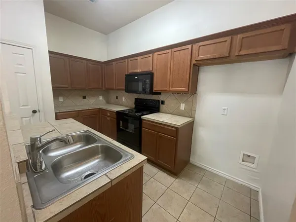 a kitchen that has a sink and a stove top oven