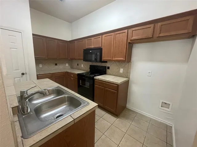 a kitchen that has a sink and a stove top oven