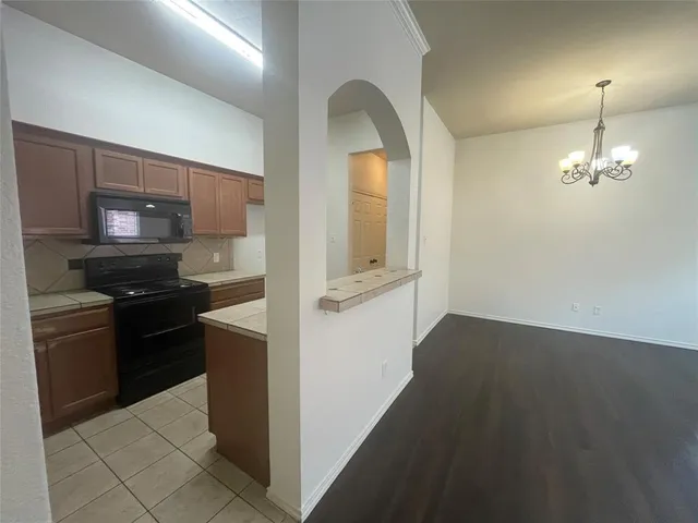 a kitchen with a refrigerator and a stove top oven