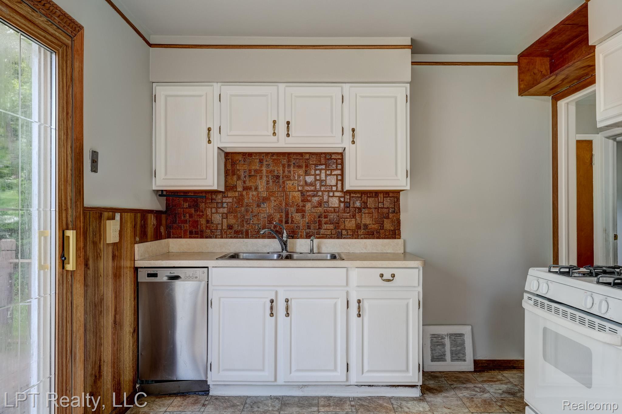 23038 Violet Street Farmington, MI 48336 - Photo 11 of 29 Kitchen area featuring white cabinetry, a stainless steel dishwasher, and a double basin sink