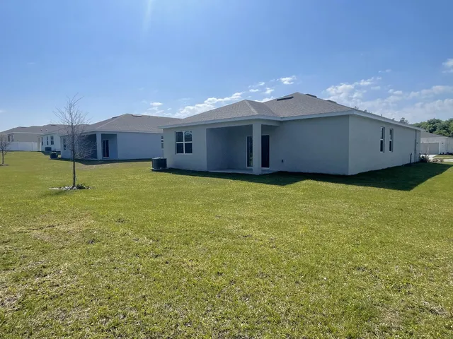 a view of a house with a backyard and a yard