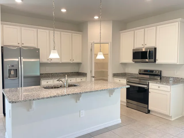 a kitchen with stainless steel appliances granite countertop a stove a sink and a refrigerator