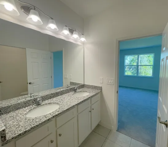 a bathroom with a granite countertop sink and a mirror