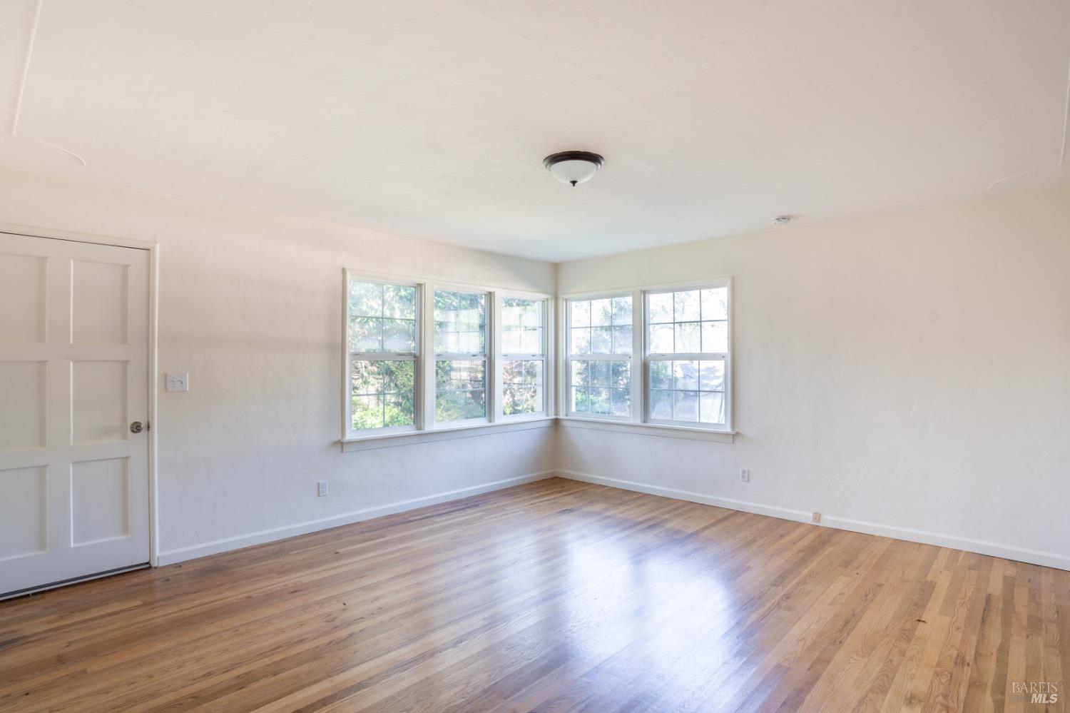490 Cornish Lane Angwin, CA 94508 - Photo 26 of 30 an empty room with wooden floor and windows