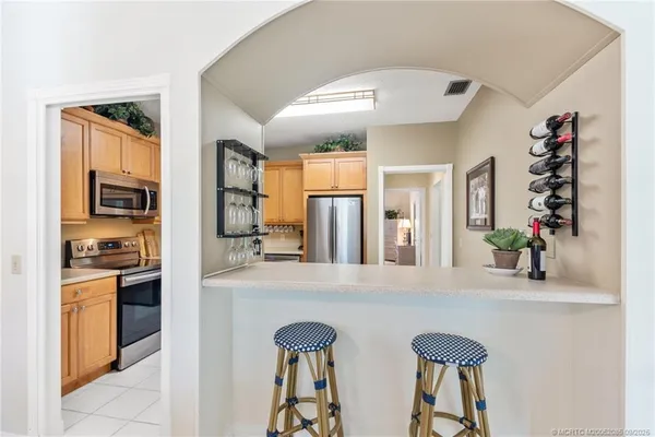 a kitchen with stainless steel appliances granite countertop a stove a sink dishwasher and a microwave oven with white cabinets