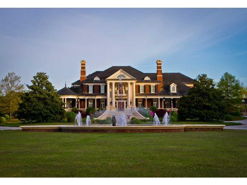 a front view of house with yard and trees in the background