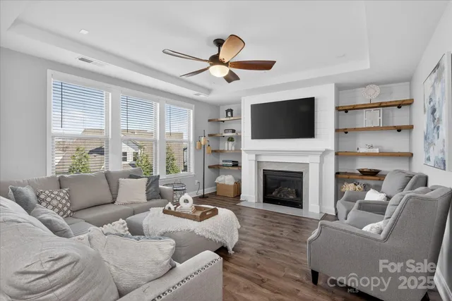 a living room with furniture a fireplace and a flat screen tv