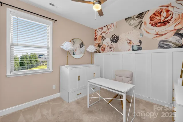 a view of a workspace with furniture and a window