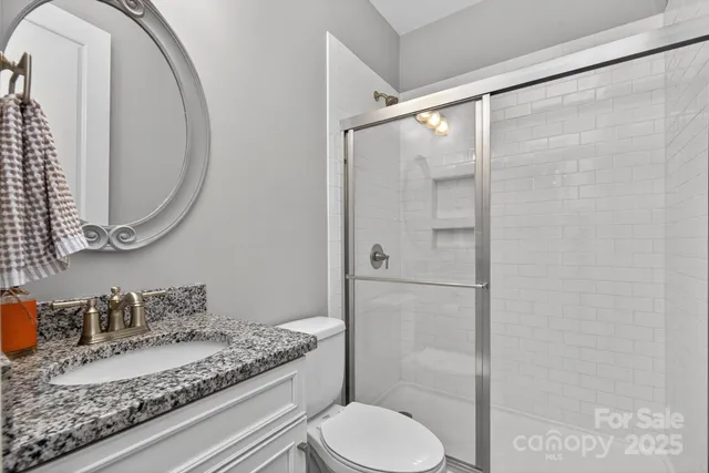 a bathroom with a granite countertop sink toilet and shower