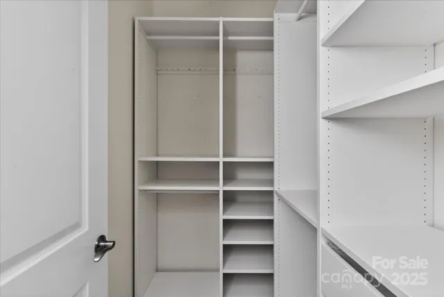a view of walk in closet with empty racks