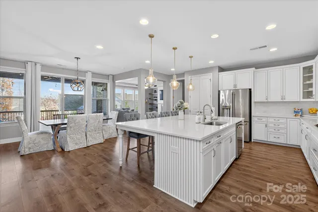 a large kitchen with stainless steel appliances kitchen island granite countertop a large center island and a sink
