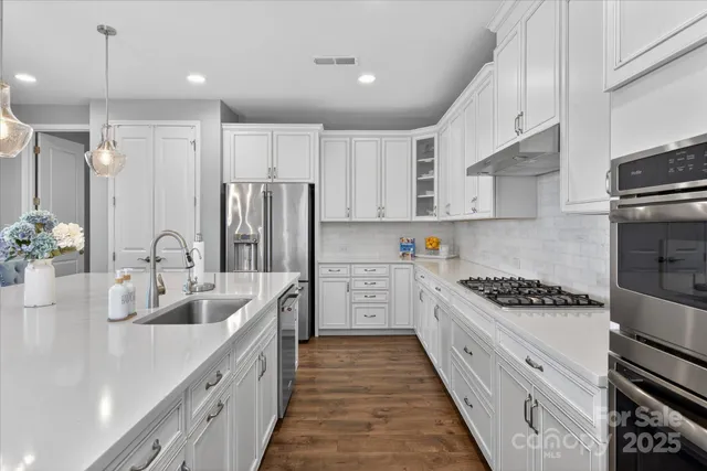 a kitchen with stainless steel appliances kitchen island granite countertop a sink and cabinets