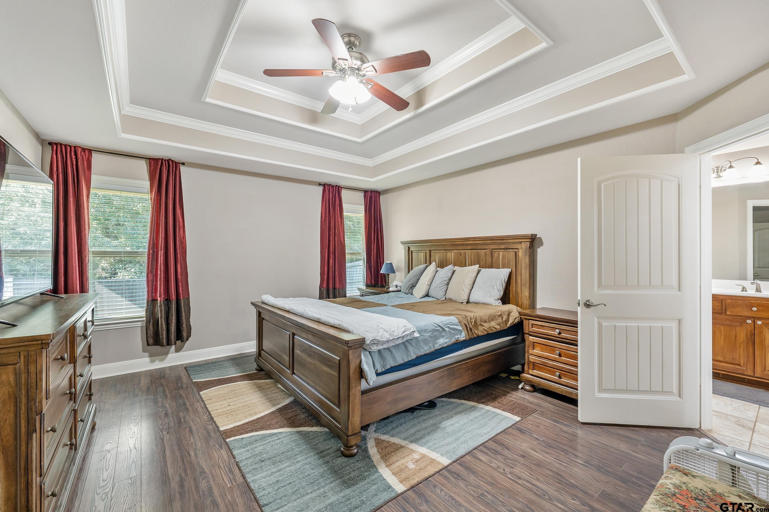 19499 Sara Lane Flint, TX 75762 - Photo 14 of 31 a bedroom with a large bed and a chandelier