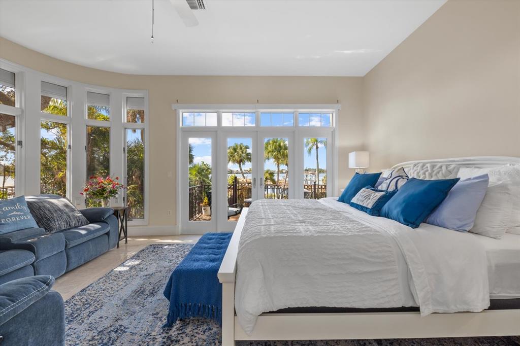 2115 Lychee Lane Nokomis, FL 34275 - Photo 15 of 85 a bed sitting in a bedroom next to a large window with couch